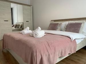 a bedroom with a large bed with towels on it at 2 Rooms Apartament Q Residence in Iaşi