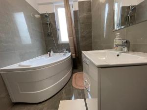 a bathroom with a tub and a sink and a toilet at 2 Rooms Apartament Q Residence in Iaşi +10 photos