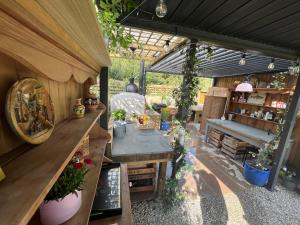 a greenhouse with a table and plants in it at Dragonfly Glamping Spa Retreat in Ashford