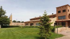 a building with a tree in front of a yard at Hotel Villa de Estercuel in Estercuel