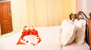 a white bed with a teddy bear on it at Naivasha Peppercorn Holiday Resort in Naivasha