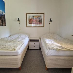 two beds sitting next to each other in a room at Strandnära hus med havsutsikt och stor tomt in Halmstad
