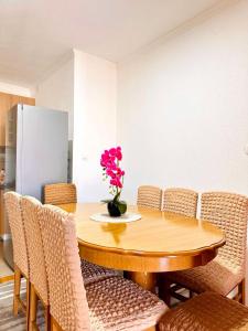 a dining room table with chairs and a vase of flowers at Apartman T&A in Trebinje +14 photos