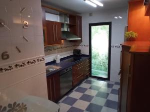 a kitchen with wooden cabinets and a glass door at Piso Auringis in Jaén