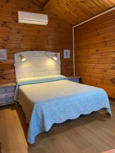 a bedroom with a bed in a wooden cabin at Casa Rural Santa Mariña in Portomarin