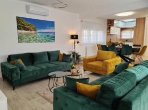 a living room with a green couch and yellow chairs at Villa Dreamin with Heated Pool & Hot Tub in Kraj