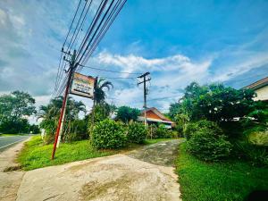 a street with a sign on the side of the road at แฮปปี้รีสอร์ทเขื่องใน in Khuang Nai
