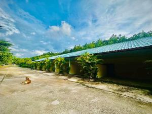 a dog sitting in a parking lot next to a building at แฮปปี้รีสอร์ทเขื่องใน in Khuang Nai +5 photos