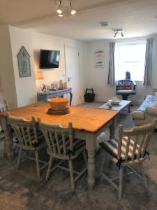 a living room with a wooden table and chairs at Bay House Lobber Port Isaac Apartment with Sea Views & Parking in Port Isaac +29 photos