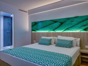 a bedroom with a bed with a painting on the wall at Comitas Floramar in Cala Galdana