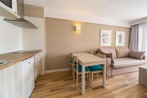 a kitchen and living room with a table and a couch at Comitas Floramar in Cala Galdana