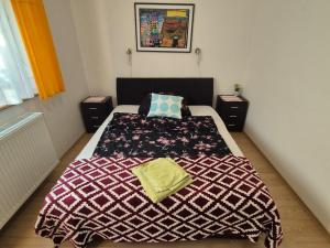 a bedroom with a bed with a blanket on it at Szahara Vendégház in Kerekegyháza