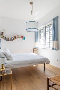 a white bedroom with a bed and a table at Maestrale in Nebbiuno