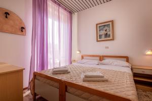 una camera da letto con un letto con due asciugamani sopra di Hotel Stradiot a Rimini