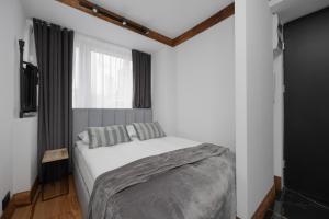 een slaapkamer met een wit bed en een raam bij Warsaw Center Elegant Studio with City View by Noclegi Renters in Warschau