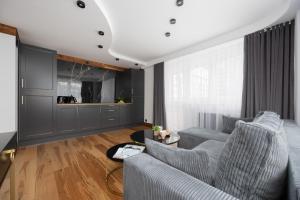 een woonkamer met een bank en een tafel bij Warsaw Center Elegant Studio with City View by Noclegi Renters in Warschau