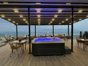 een hot tub op een terras met tafels en stoelen bij Blue View Apartments in Kavala