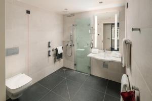 a bathroom with a toilet and a sink and a shower at IntercityHotel Heidelberg in Heidelberg +22 photos