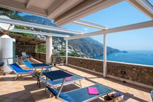 a house with a balcony with chairs and the ocean at Villino Blu in Praiano