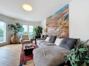 a living room with a couch and a painting on the wall at Classy T3 with terrace in Saint-Ouen