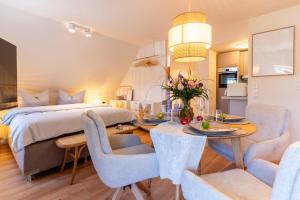 een slaapkamer met een bed, een tafel en stoelen bij Studio - Kleiner Ostsee Hof in Großenbrode