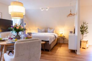 een slaapkamer met een bed, een tafel en stoelen bij Studio - Kleiner Ostsee Hof in Großenbrode