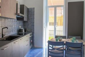 a kitchen with a sink and a table with chairs at WANDERLUST Aria di Mare in Naples
