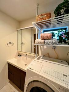 a laundry room with a washing machine and a sink at Brand New Modern Haven 7-Min Walk to Shinkoenji Station 9-Min Train to Shinjuku in Tokyo
