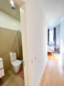 a white bathroom with a toilet and a bedroom at Large apartment on Rua Augusta in Lisbon