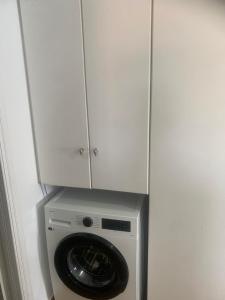 a washing machine with a cabinet on top of it at Kamari Beachfront Apartments in Xylokastro