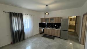 a kitchen with wooden cabinets and a refrigerator at Το ΦΑΡΑΓΓΙ Του ΠΑΡΝΑΣΣΟΥ in Velítsa