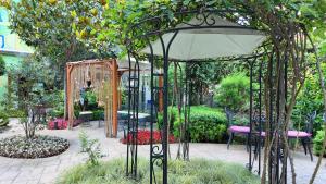 a gazebo with an umbrella in a garden at Tuzla Garden Hotel & Spa in Tuzla