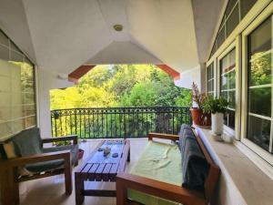 eine Veranda mit Sofa und Tisch auf einem Balkon in der Unterkunft Wenge in Karaburma