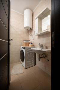 Un baño con lavadora y lavabo. en La Casa Studio Apartman, en Subotica 25 fotos más