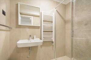 a bathroom with a sink and a shower with a mirror at Hotel Hermes Budva in Budva
