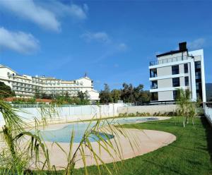 a building with a swimming pool in front of a building at ATICO BOHIO premium in Benicàssim