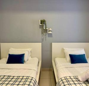 two beds with blue pillows in a room at NEW - Panorama Komtar SeaView Meritime Suites in Jelutong