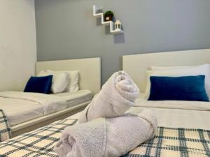 a room with two beds and a towel on the bed at NEW - Panorama Komtar SeaView Meritime Suites in Jelutong