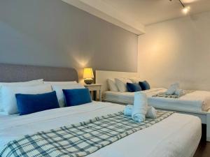two beds with blue and white pillows in a room at NEW - Panorama Komtar SeaView Meritime Suites in Jelutong +23 photos