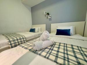 a room with two beds with a stuffed animal on the floor at NEW - Panorama Komtar SeaView Meritime Suites in Jelutong