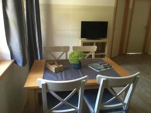 a dining room table with two chairs and a tv at Büchlhof - App. Himmelalm in Lilienfeld