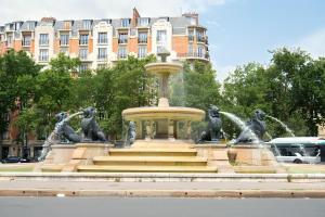einen Brunnen mit Löwenstatuen vor einem Gebäude in der Unterkunft Chambre privée proche Accord Arena et avec metro 20 min de la Tour Eiffel in Paris