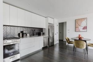 een keuken met witte kasten en een tafel met stoelen bij Blueground Upper East Side fully equipped NYC-1545 in Brooklyn