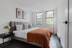 een witte slaapkamer met een bed en twee ramen bij Blueground Upper East Side fully equipped NYC-1545 in Brooklyn