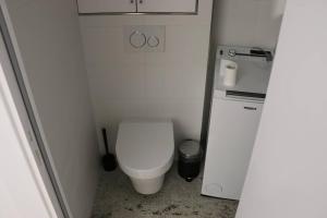 ein kleines Badezimmer mit Toilette und Kühlschrank in der Unterkunft Chambre privée proche Accord Arena et avec metro 20 min de la Tour Eiffel in Paris + 2 Fotos