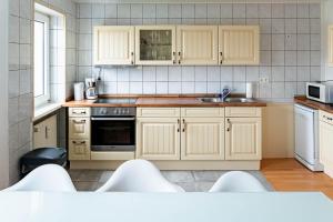 a kitchen with white cabinets and a stove top oven at CBlue "Admiralsloge - Nauticus" in Warnemünde +8 photos