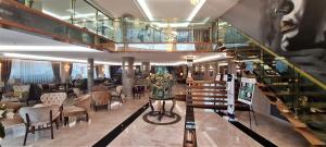 a hotel lobby with a staircase and a restaurant at Tuzla Garden Hotel & Spa in Tuzla