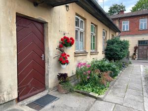 a building with a red door with flowers on it at Katrīnas apartamenti in Kuldīga
