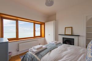 een slaapkamer met een bed, een open haard en een raam bij Sea Spray Cottage by Bloom Stays in Sandgate