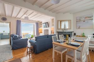 een woonkamer met een blauwe bank en een tafel bij Sea Spray Cottage by Bloom Stays in Sandgate